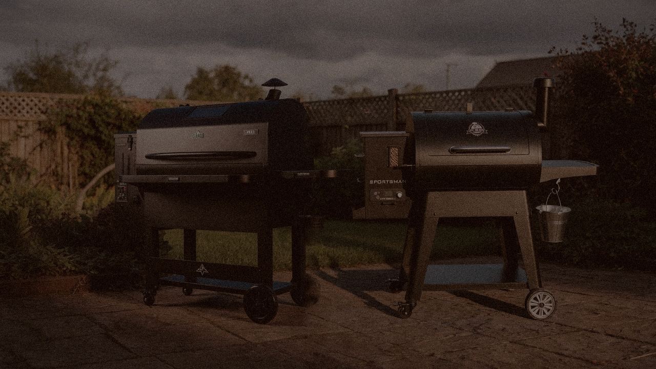 Green Mountain Grills Peak and Pit Boss Navigator 850 at night with smoke, wood pellet grills on a dark patio