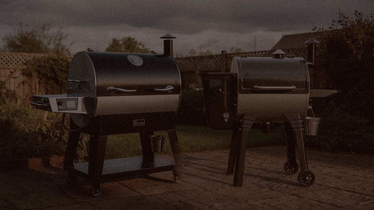recteq Flagship 1600 and Camp Chef Woodwind WiFi 24 at night with smoke, wood pellet grills on a dark patio