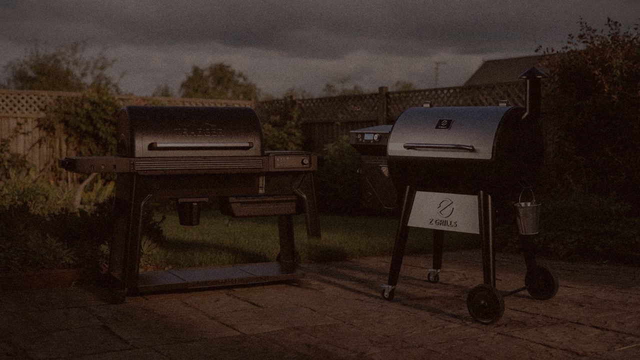 Traeger Ironwood and Z Grills 700 Series (ZPG-7002) at night with smoke, wood pellet grills on a dark patio